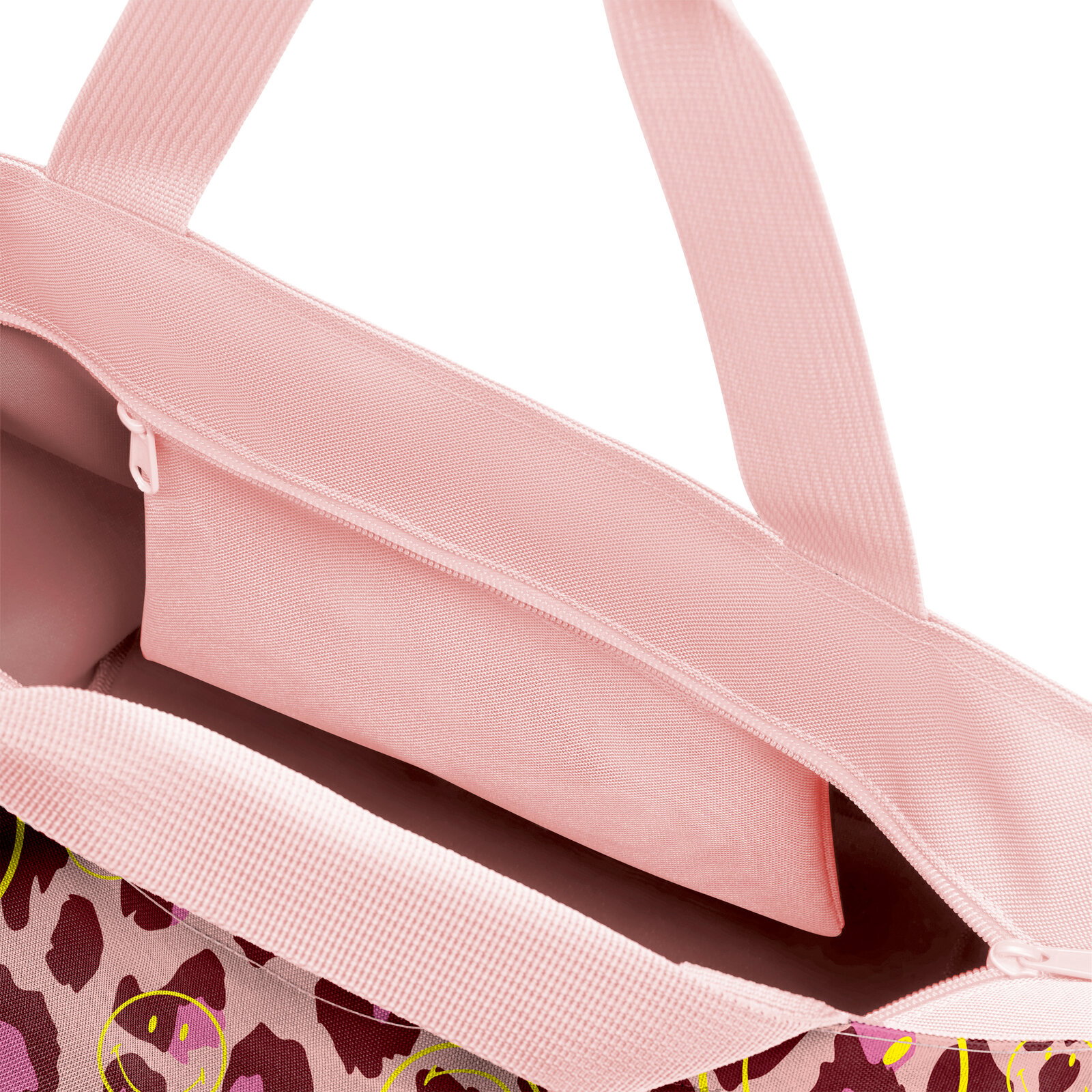 Nahaufnahme von oben in die geöffnete rosa Tragetasche mit Reißverschluss, Innenfach und Tragegriffen außen mit Leopardenmuster und Smiley-Print auf weißem Hintergrund