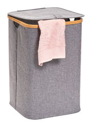 Grauer Wäschesammler mit Holzrahmen und rosa Handtuch, seitliche Perspektive