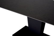 Moderne zwarte eettafel gezien vanaf de zijkant, met een rechthoekig tafelblad en een stevige middenpoot.