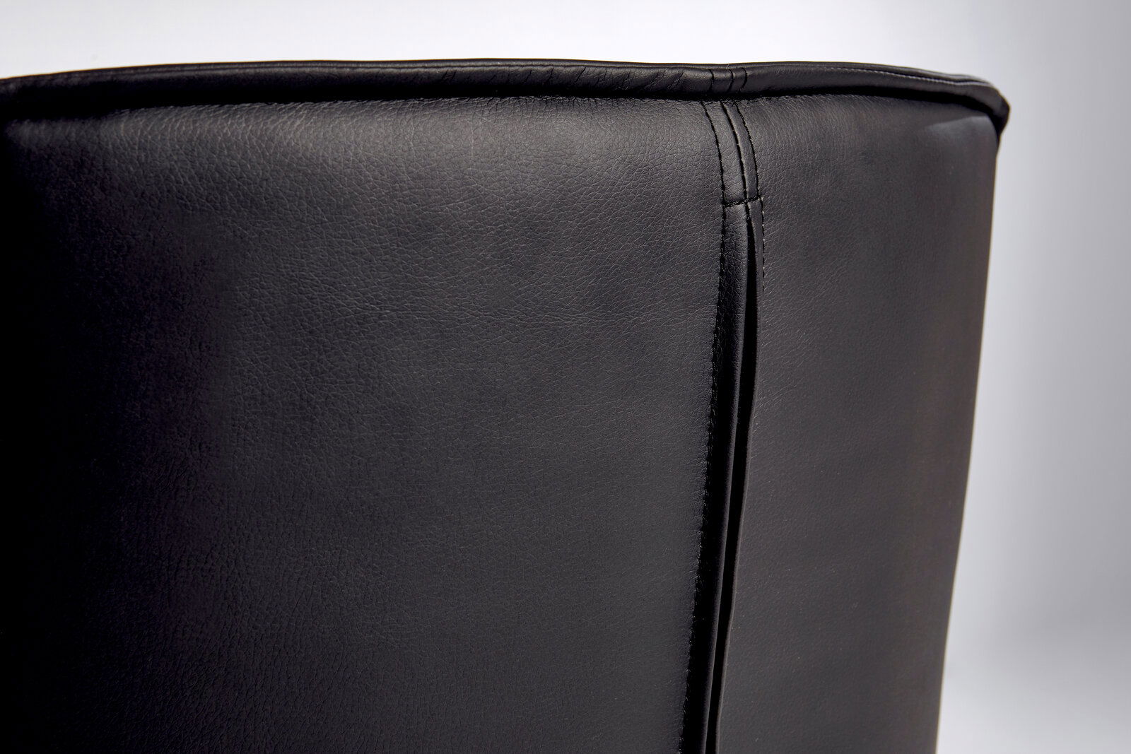 Nahaufnahme der Rückseite eines schwarzen Bürostuhls aus Leder, seitliche Perspektive