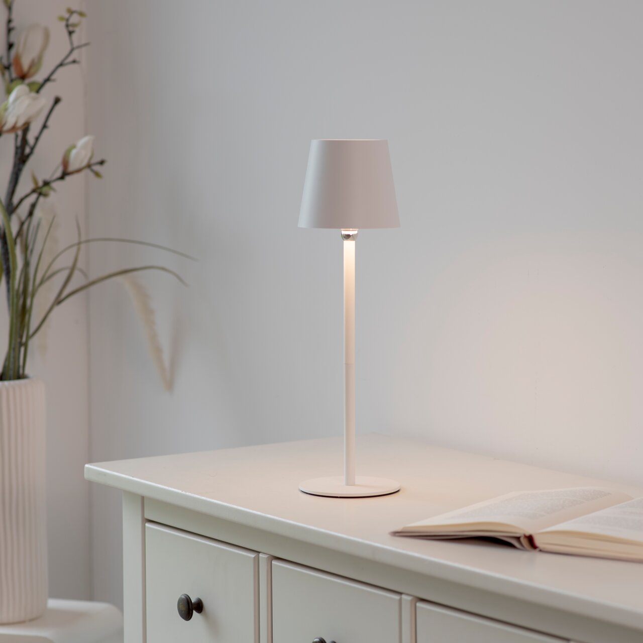 Elegante BOTERIA-batterijtafellamp in wit op een tafel, zijaanzicht