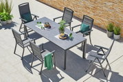 Een moderne stapelstoel op een terras, omringd door een tafel en andere stoelen, gefotografeerd vanuit vogelperspectief.