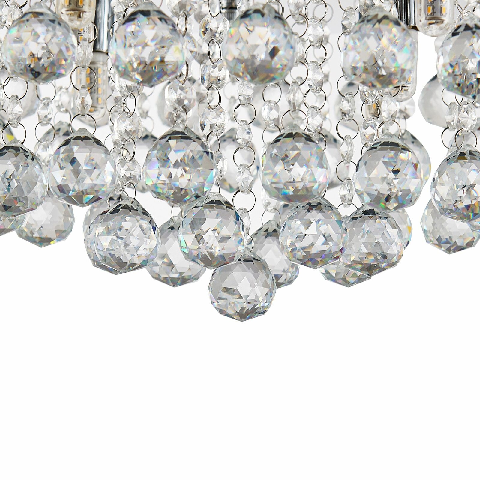 Nahaufnahme einer Deckenleuchte mit funkelnden Kristallanhängern, von unten betrachtet.