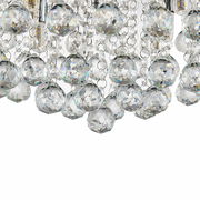 Nahaufnahme einer Deckenleuchte mit funkelnden Kristallanhängern, von unten betrachtet.