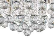 Nahaufnahme einer Deckenleuchte mit funkelnden Kristallanhängern, von unten betrachtet.