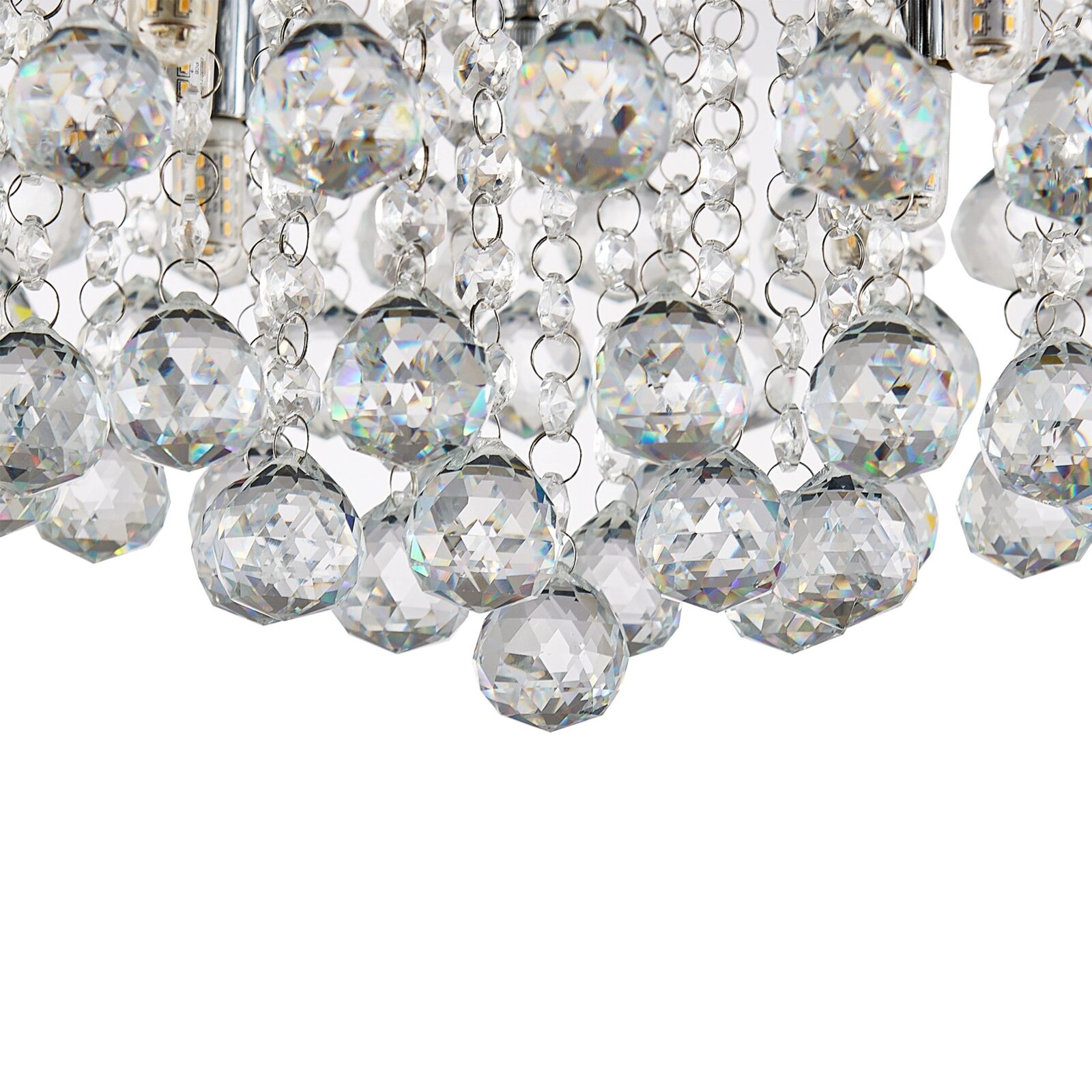Close-up van een plafondlamp met schitterende kristallen hangers, gezien van onderaf.