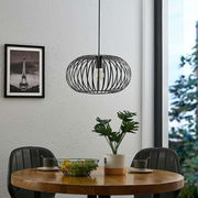 Moderne Hängeleuchte mit schwarzem, drahtigem Design über einem Esstisch, seitliche Perspektive.