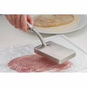 Fleischklopfer PROFI PLUS aus Edelstahl, in der Hand gehalten, von oben auf ein Stück Fleisch auf einem Schneidebrett gedrückt.