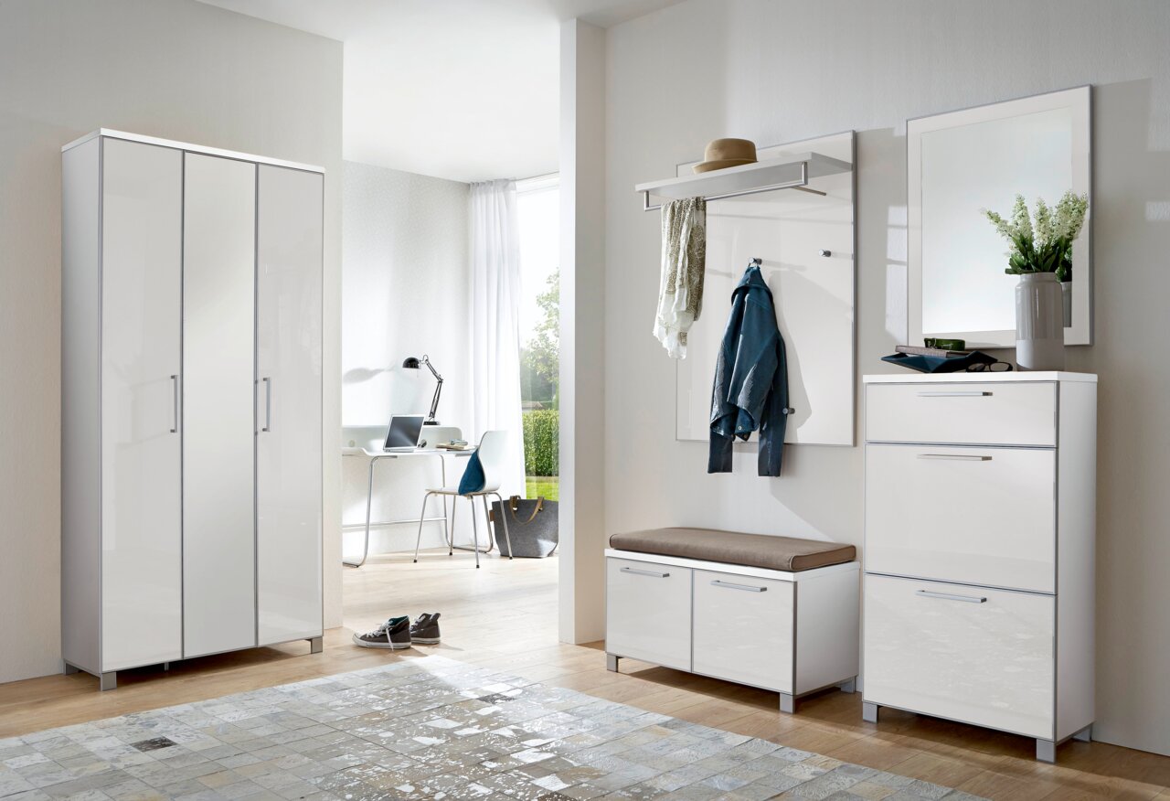 Modernes Garderoben-Set in Weiß, bestehend aus einem hohen Schrank, einer Sitzbank mit Stauraum, einer Wandgarderobe mit Haken und Ablage sowie einem Spiegel. Perspektive: Frontalansicht.