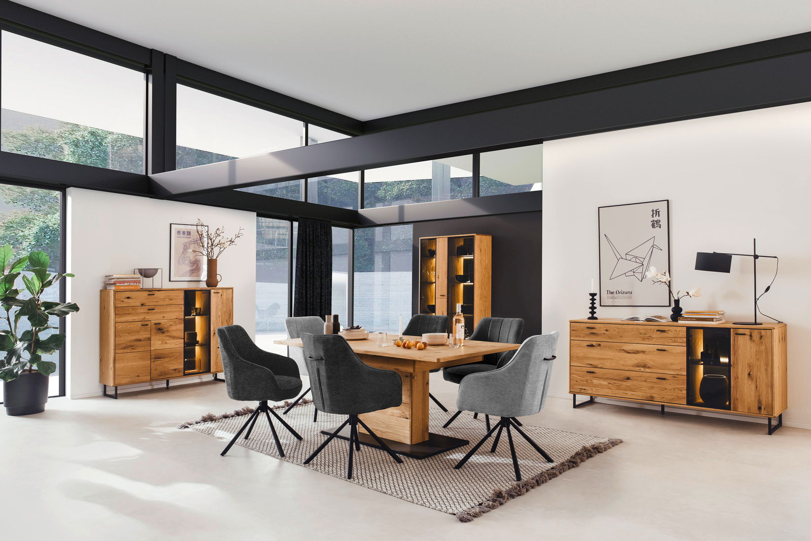 Moderne Esszimmermöbel in einem hellen Raum mit großen Fenstern, bestehend aus einem Holztisch, grauen Stühlen und beleuchteten Vitrinen. Perspektive: Frontalansicht.