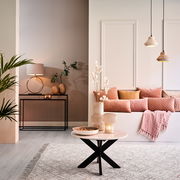 Moderner Wohnraum mit stilvollem Lampenfuß LIVA auf einem schwarzen Konsolentisch, umgeben von eleganten Dekorationen und warmen Farbtönen, seitliche Perspektive.