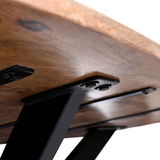 Nahaufnahme der Unterseite eines Esstisches mit massiver Holzplatte und stabilen schwarzen Metallbeinen, Perspektive von unten.