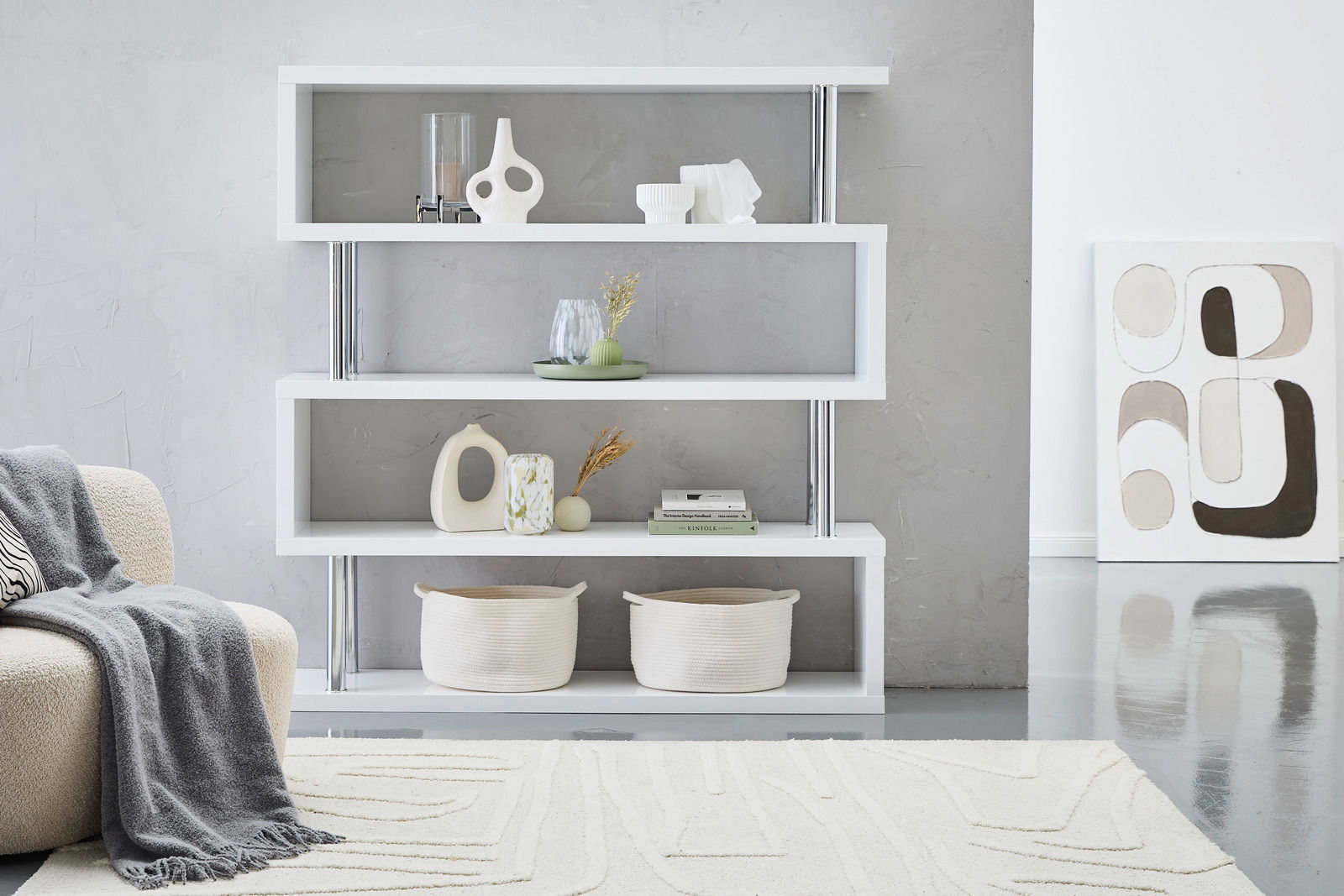 XORA Regal KAZUMI Modernes, großes XORA Regal KAZUMI in Weiß mit vier Regalböden, dekoriert mit Vasen und Körben, seitliche Perspektive.