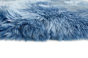 Nahaufnahme eines blauen Schaffells mit weicher, flauschiger Textur, seitliche Perspektive