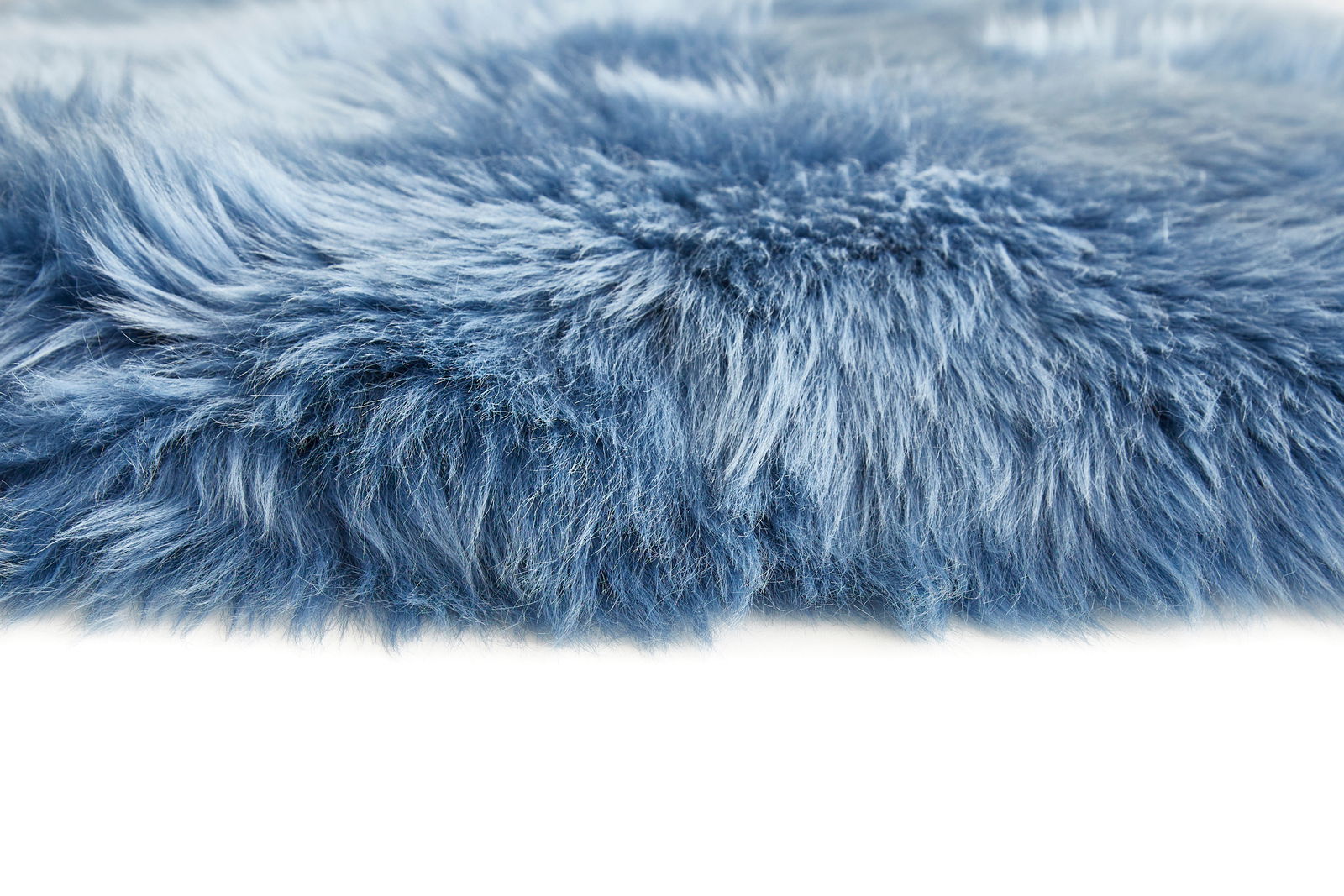 Nahaufnahme eines blauen Schaffells mit weicher, flauschiger Textur, seitliche Perspektive