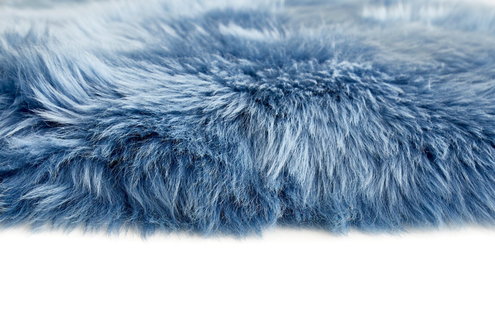 Close-up van een blauwe schapenvacht met een zachte, donzige textuur, gezien vanaf de zijkant