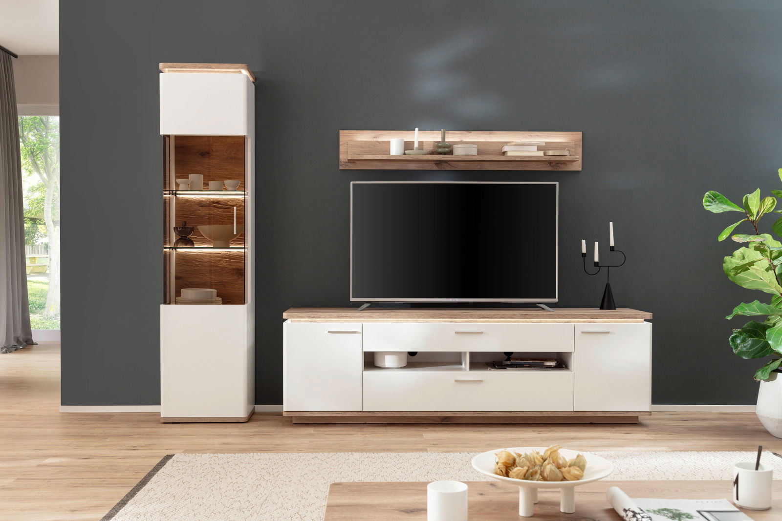 Moderne Wandkombination in Weiß und Holzoptik mit TV-Schrank, Regal und Vitrine, frontal fotografiert.