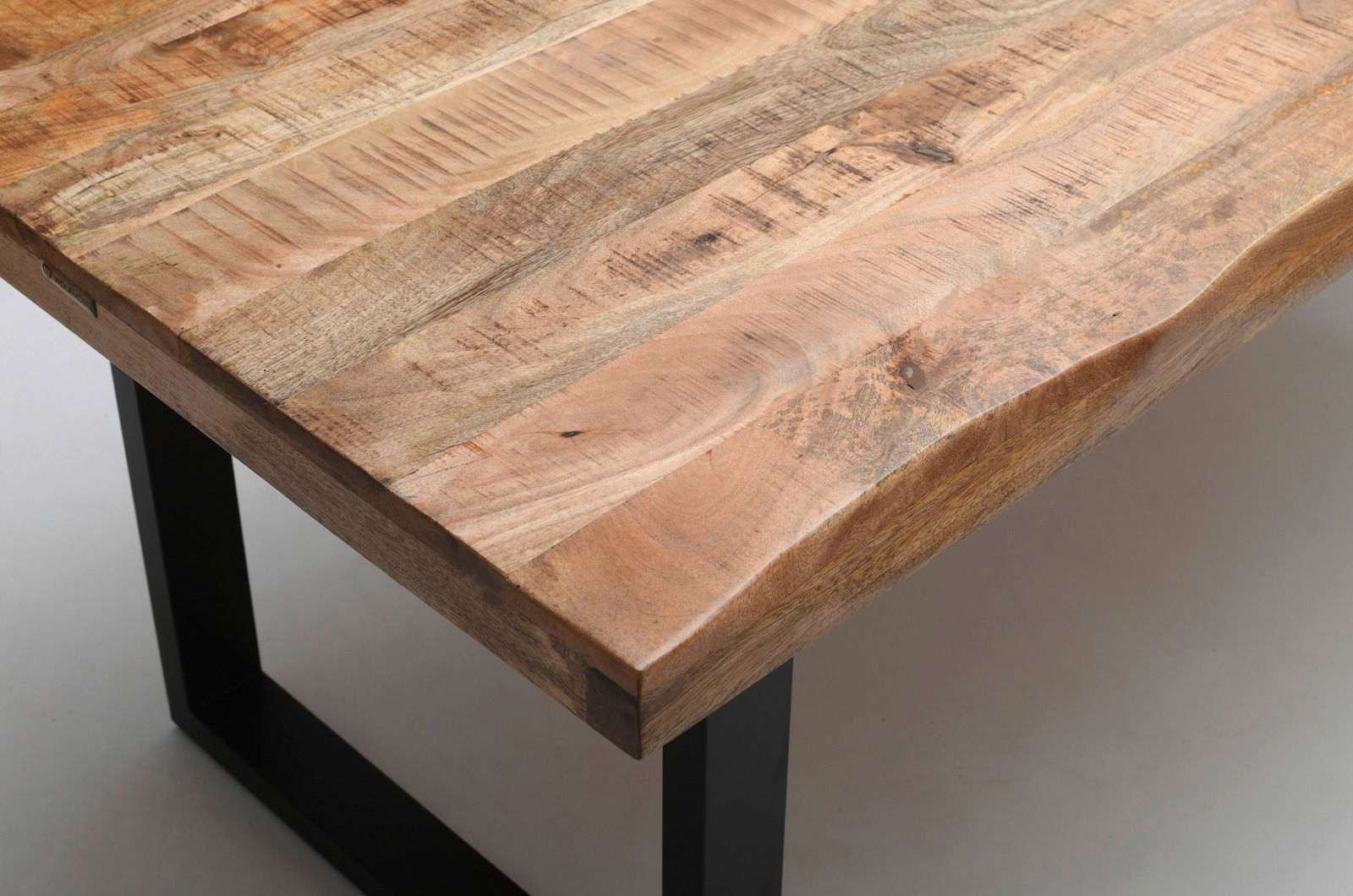 Nahaufnahme eines Esstisches aus Holz mit natürlicher Maserung und schwarzen Metallbeinen, Perspektive von oben.