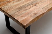 Nahaufnahme eines Esstisches aus Holz mit natürlicher Maserung und schwarzen Metallbeinen, Perspektive von oben.