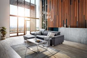 Moderne graue Rundecke in einem stilvollen Wohnzimmer mit großen Fenstern und Holzwandverkleidung, seitliche Perspektive.