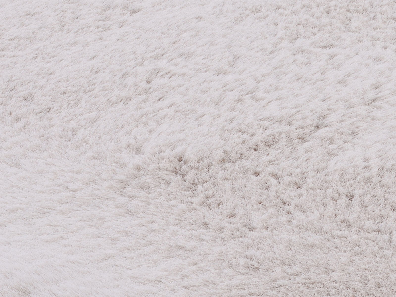 Nahaufnahme eines weißen Fellteppichs mit weicher Textur.