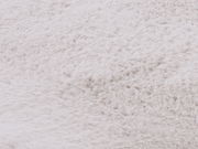 Nahaufnahme eines weißen Fellteppichs mit weicher Textur.