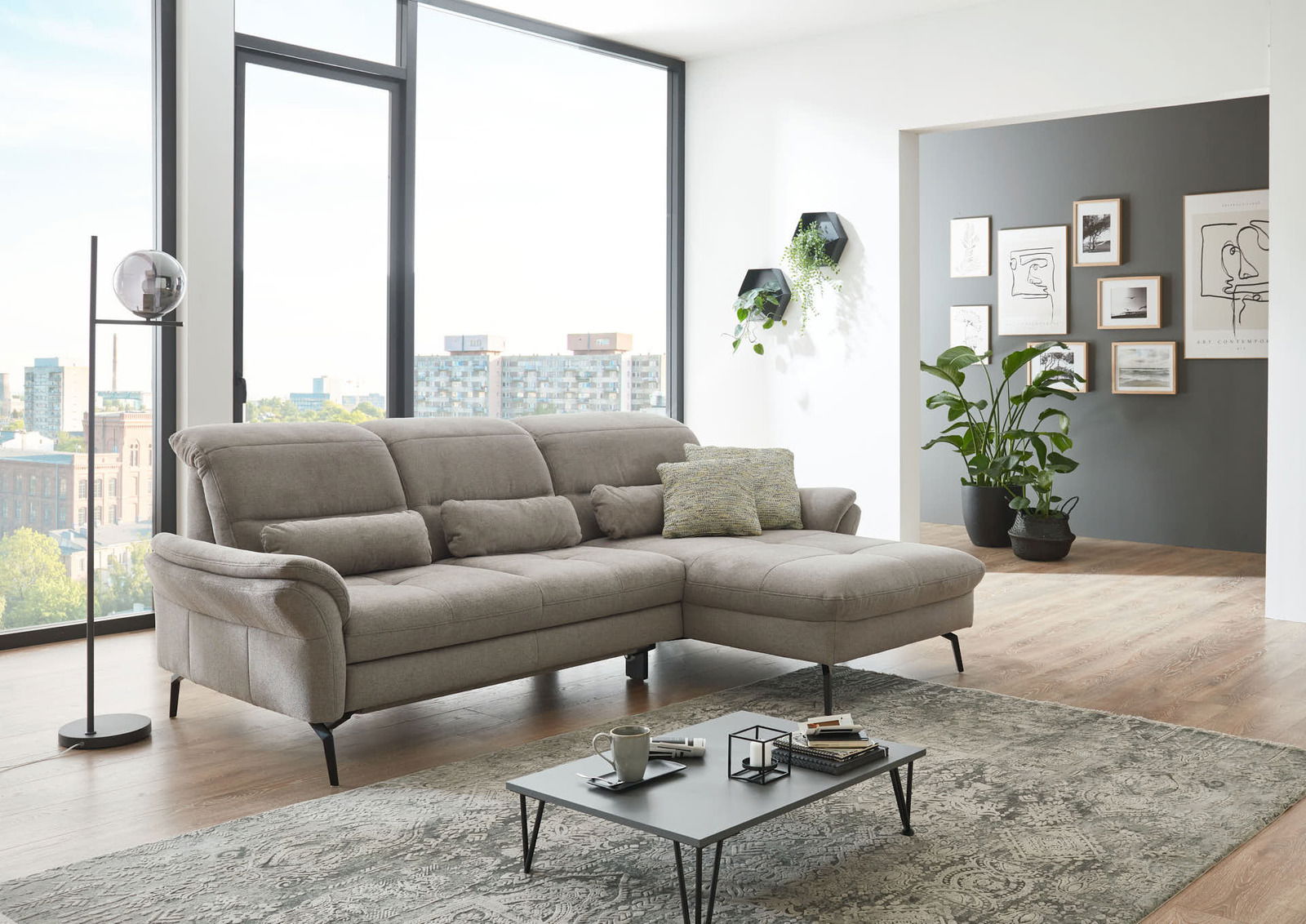 Graue Longchairkombination in modernem Wohnzimmer mit großen Fenstern und stilvoller Dekoration, seitliche Perspektive.