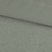 Grüne Wendebettwäsche mit feinem Streifenmuster und einfarbiger Seite, aus der Vogelperspektive fotografiert.