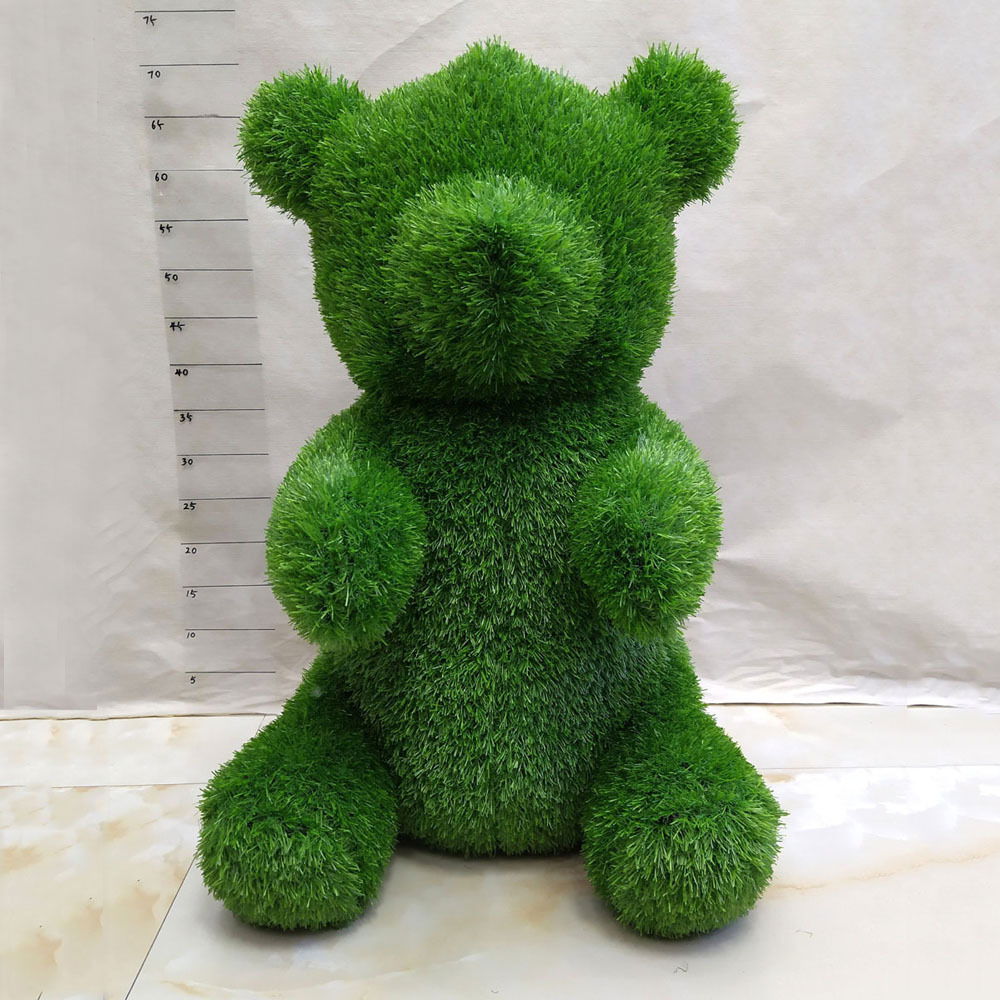 Grüne Bärenfigur aus Gras, frontalansicht, Gartendekoration