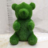 Grüne Bärenfigur aus Gras, frontalansicht, Gartendekoration