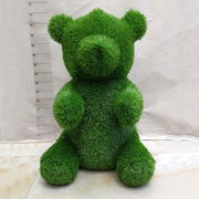 Grüne Bärenfigur aus Gras, frontalansicht, Gartendekoration
