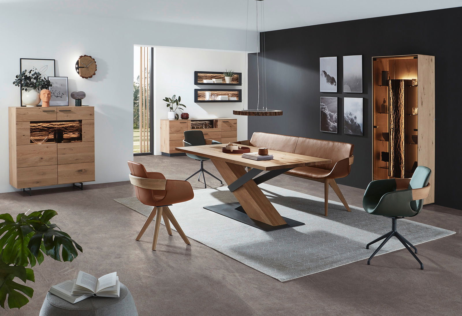 Moderner Esstisch aus Holz mit X-förmigem Gestell, umgeben von stilvollen Stühlen und einer Bank, in einem eleganten Wohnzimmer mit dunkler Akzentwand. Perspektive: seitlich.