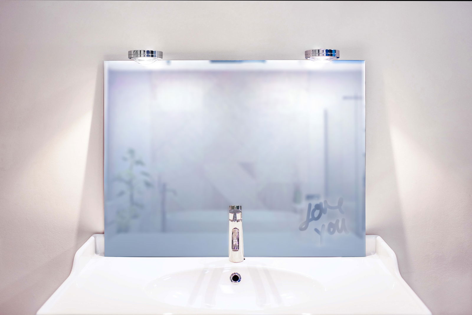 Megatron LED-Bad- / Spiegelklemmleuchte IL NOSTRO LED Bad- und Spiegelklemmleuchte über einem modernen Waschbecken, frontal betrachtet.