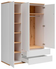 Offener weißer Kleiderschrank mit Holzdekor, Regalfächern links, Kleiderstange und Ablage rechts sowie zwei ausgezogenen Schubladen, in schräger Frontansicht