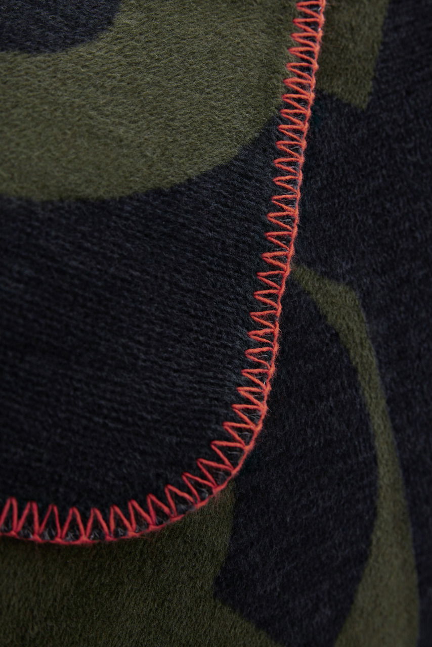 s.Oliver Tagesdecke Nahaufnahme einer Jacquard-Decke mit grünem und schwarzem Muster und roter Ziernaht.