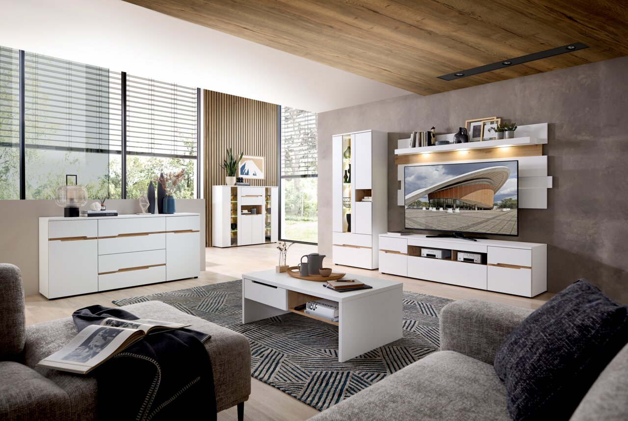 Z2 Wohnwand MEMPHIS Moderne Wohnwand in einem stilvollen Wohnzimmer mit weißem und holzfarbenem Design, aus der Perspektive eines gemütlichen Wohnbereichs mit Sofa und Couchtisch.