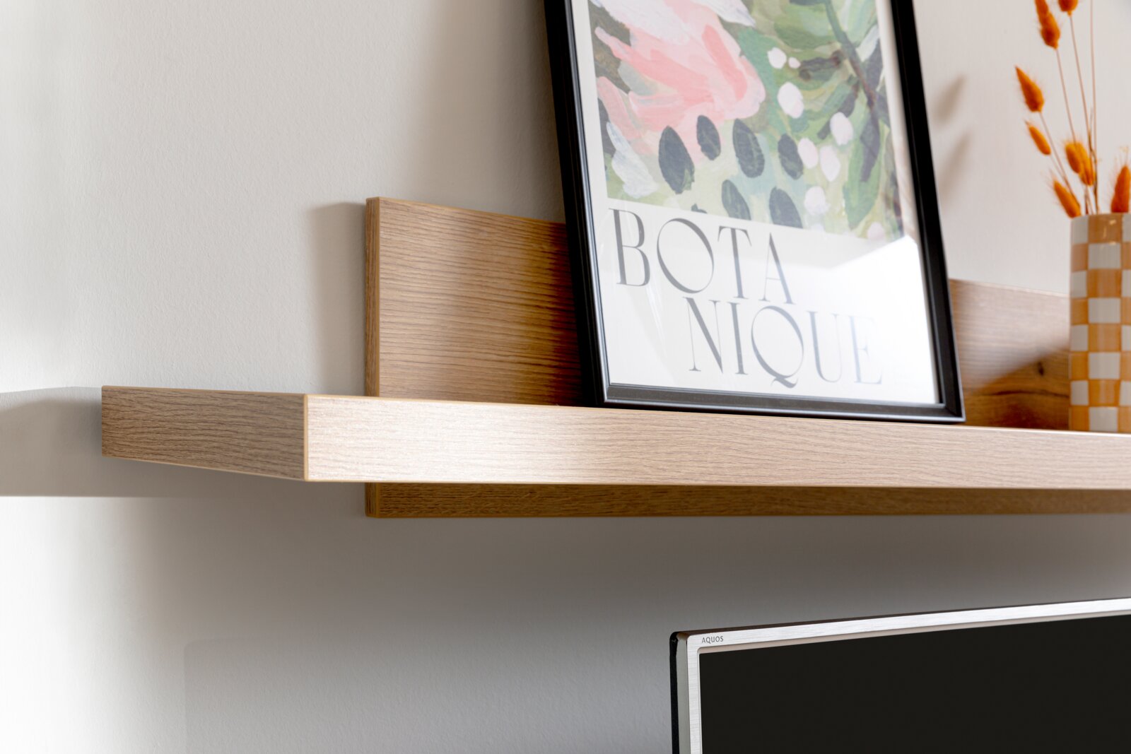 Houten wandplank met decoratieve afbeelding en vaas, zijaanzicht