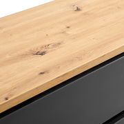 Nahaufnahme einer Kommode mit einer Holzoberfläche und einem schwarzen Korpus, Perspektive von oben.