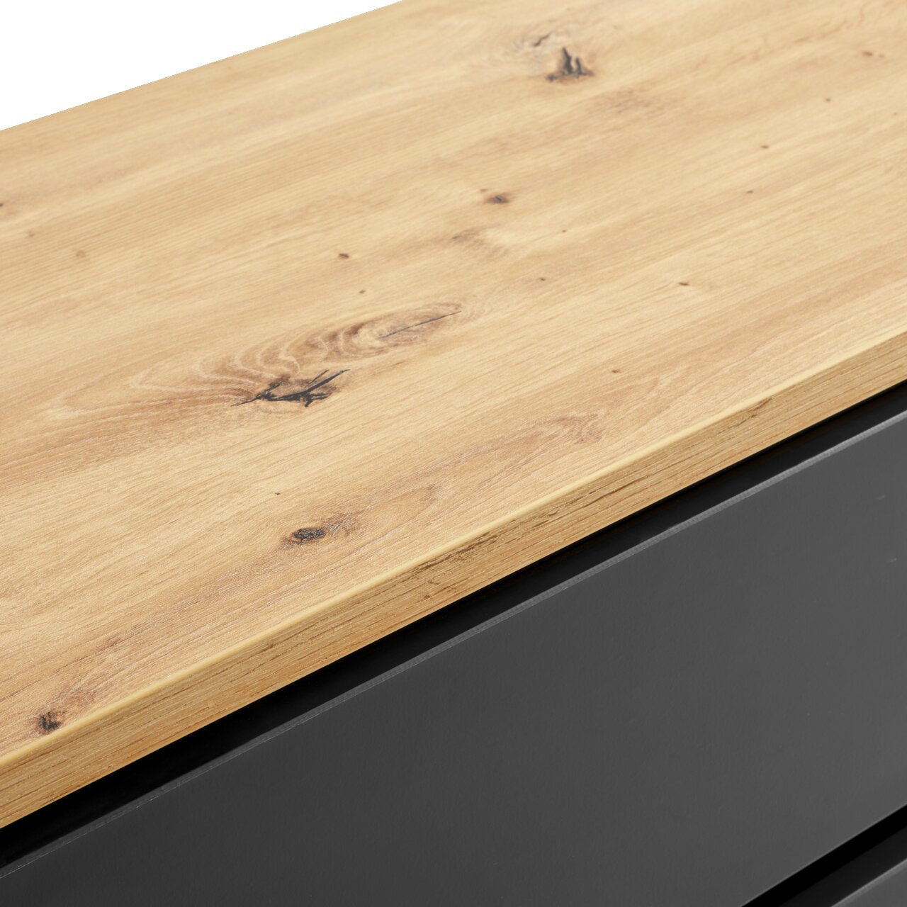 Nahaufnahme einer Kommode mit einer Holzoberfläche und einem schwarzen Korpus, Perspektive von oben.