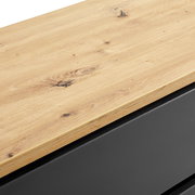 Nahaufnahme einer Kommode mit einer Holzoberfläche und einem schwarzen Korpus, Perspektive von oben.