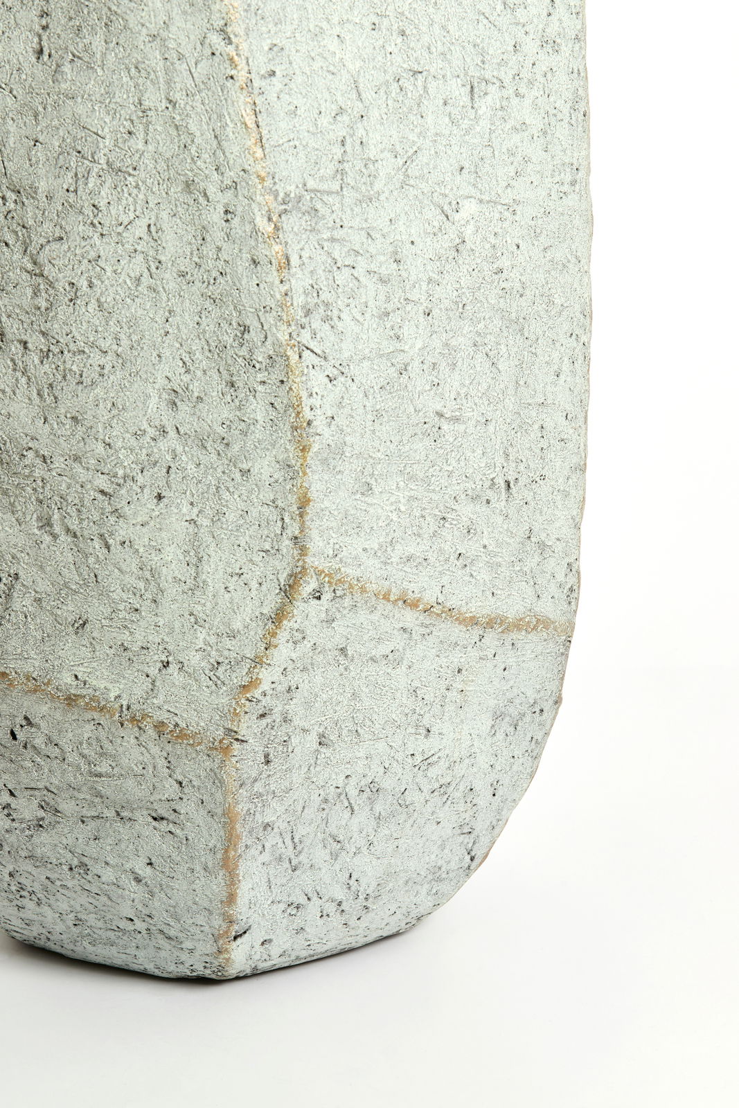 Nahaufnahme eines eckigen, strukturierten Topfes aus Betonmaterial, seitliche Perspektive