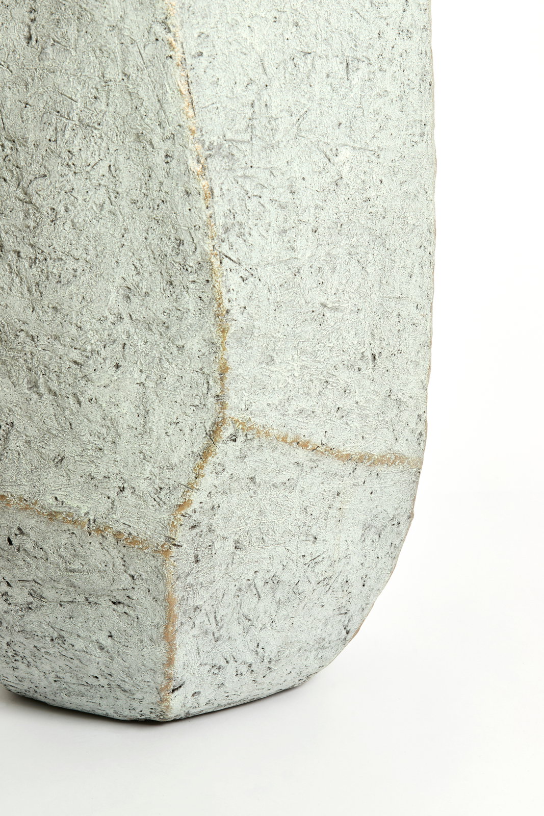 Nahaufnahme eines eckigen, strukturierten Topfes aus Betonmaterial, seitliche Perspektive