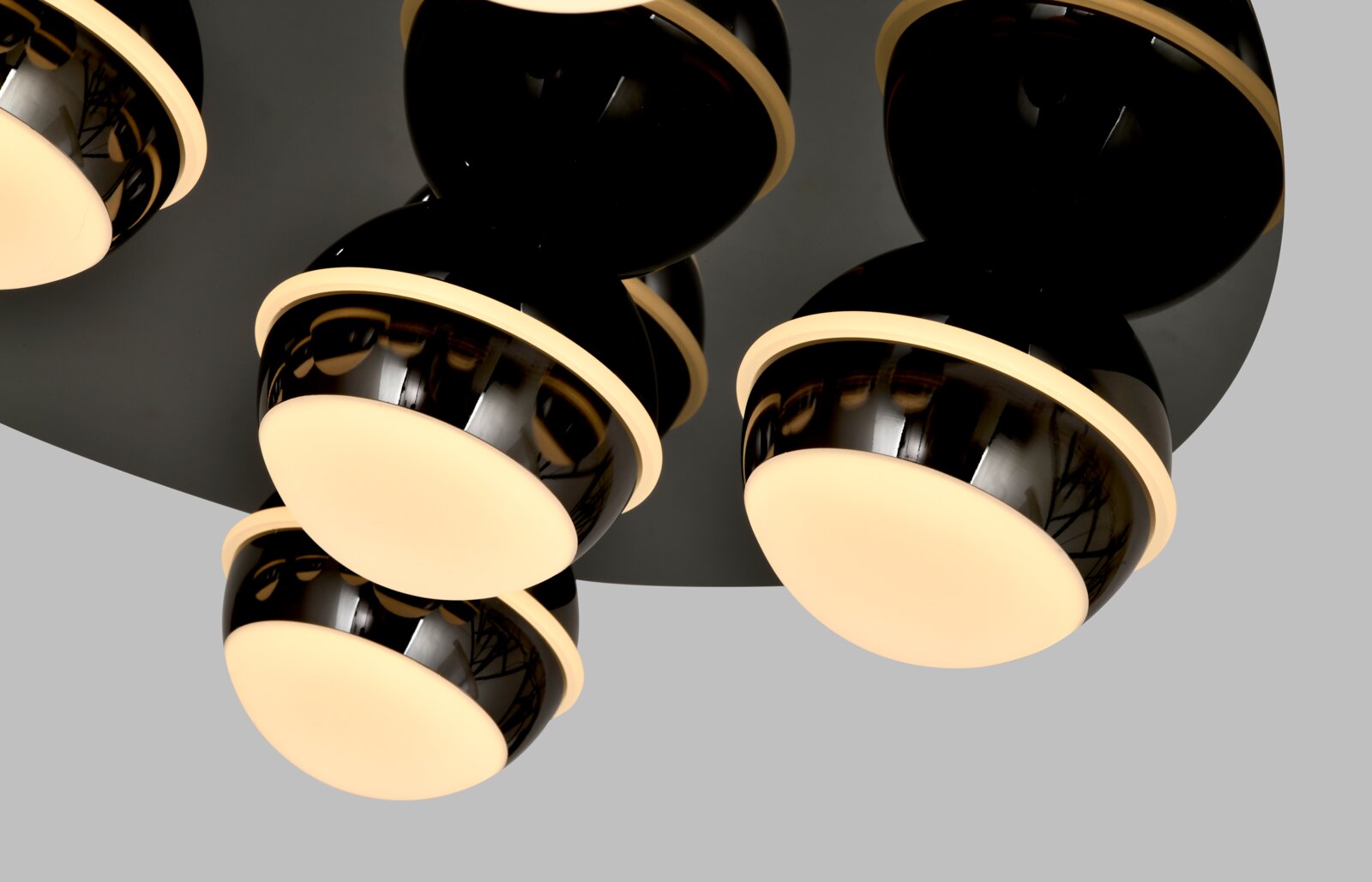Moderne led-plafondlamp met meerdere bolvormige, glanzend zwarte lampenkappen en warmwitte lichtbronnen, gezien vanaf de zijkant.