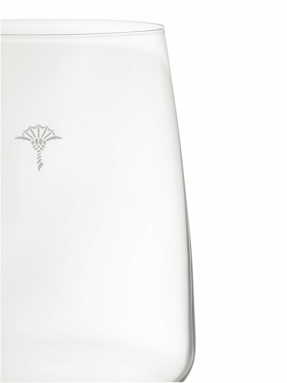 Nahaufnahme eines Weißweinglases mit dezentem Logo, seitliche Perspektive.