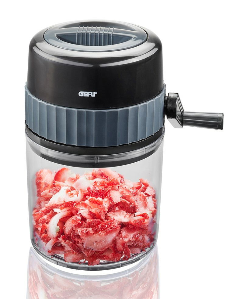 Eiscrusher mit Kurbel, gefüllt mit zerkleinertem Eis und roten Früchten, seitliche Perspektive