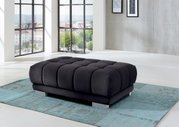 XXL-Hocker in modernem Wohnzimmer, seitliche Perspektive, mit großen Fenstern im Hintergrund.