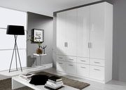 Moderner weißer Drehtürenschrank mit mehreren Türen und Schubladen, seitliche Perspektive im stilvollen Wohnzimmer.