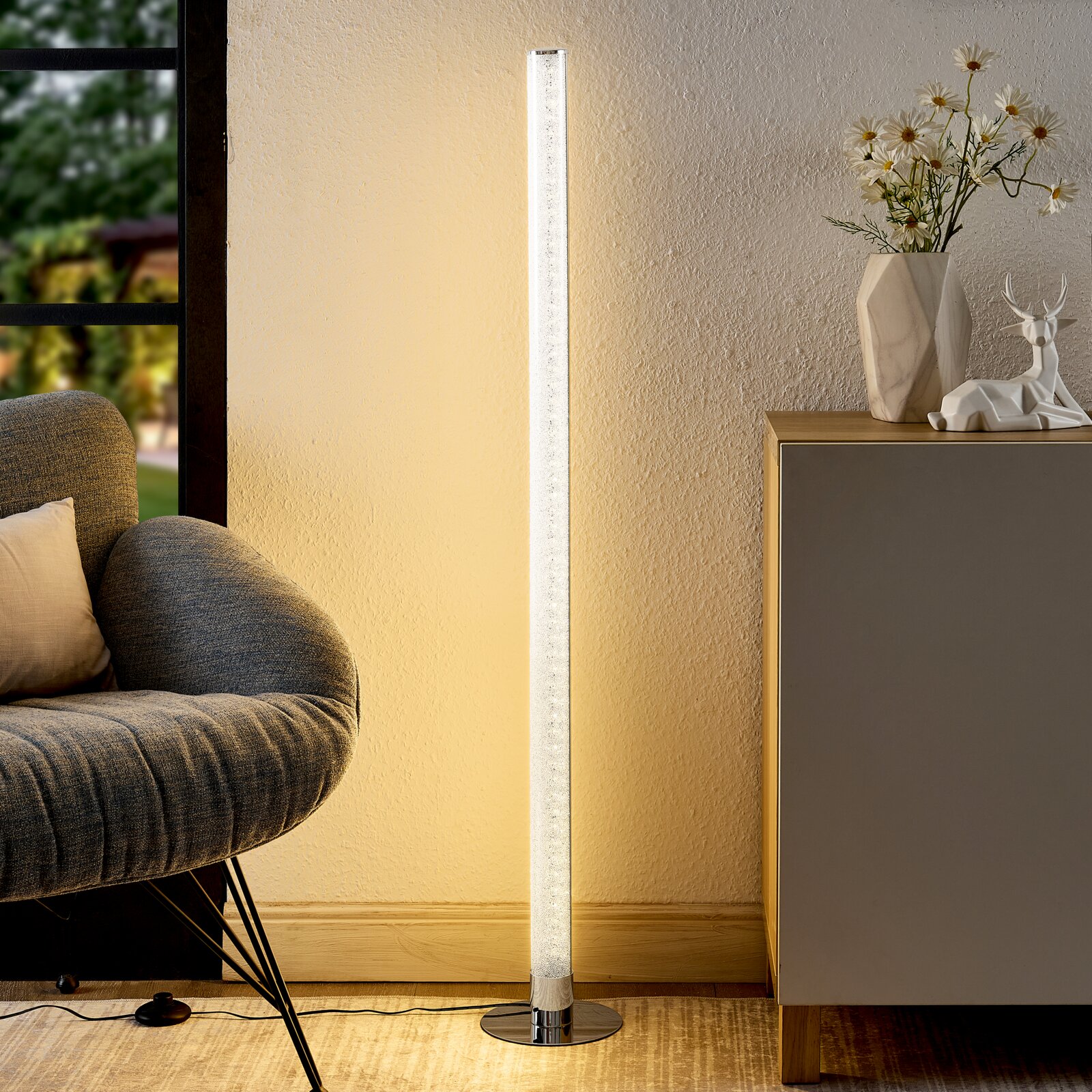 Moderne LED-Stehleuchte in einem gemütlichen Wohnzimmer, seitliche Perspektive