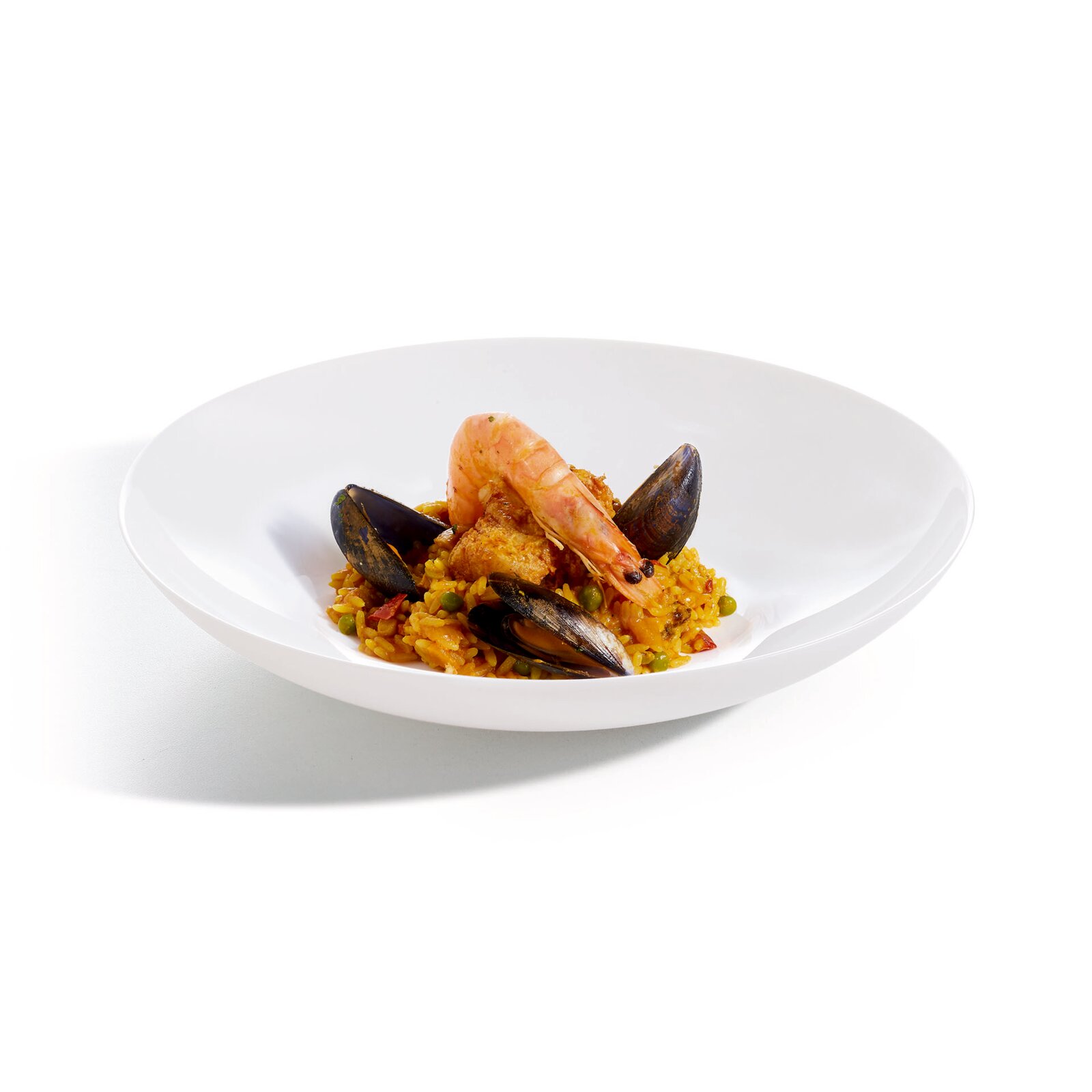 Meeresfrüchte-Paella mit Garnele und Miesmuscheln in einem tiefen weißen Teller, in leichter Seitenansicht (3/4-Perspektive) vor hellem Hintergrund.