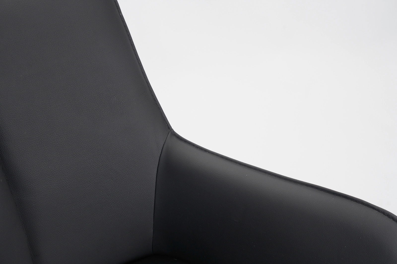 Nahaufnahme eines schwarzen Barhockers aus Leder, Fokus auf die Rückenlehne.